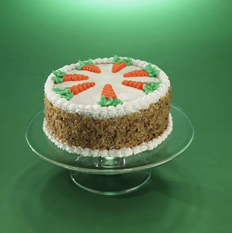 Carrot-decorated cake on a glass stand