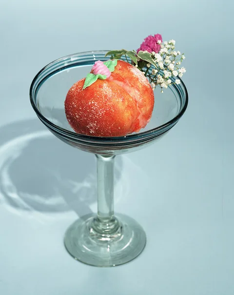 Peach-shaped pastry on a glass dish